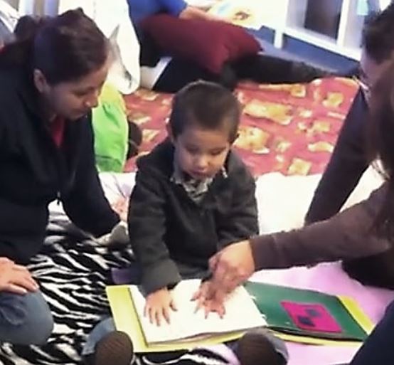 A blind child using a tactile approach to learning which is a precursor to learning Braille